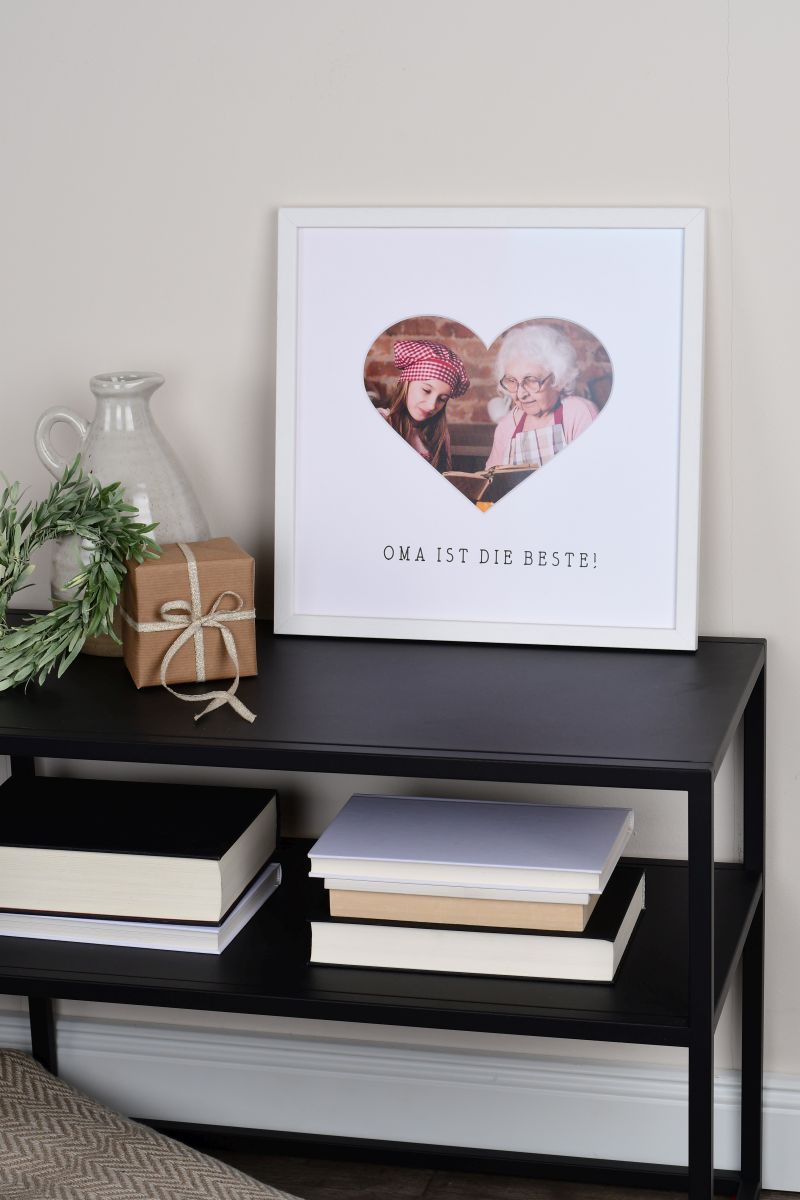 Marco de fotos 30x30 en blanco con abertura de corazón para la abuela en un ambiente hogareño.